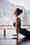 Side view of a woman practicing yoga in a studio with a view of mountains.